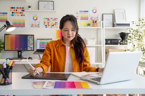 Female designer creating digital designs in a bright studio